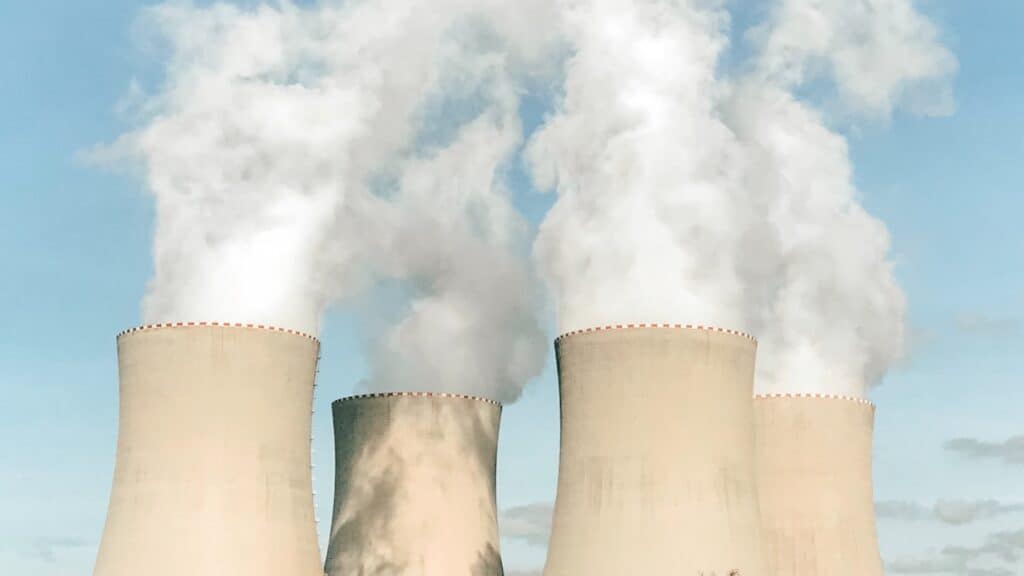 Four smokestacks against a blue sky.