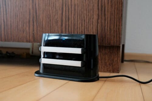 The charging dock for the ILIFE A11 on a wooden floor.