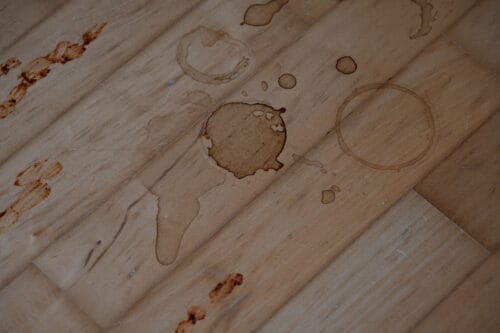 Coffee, tomato sauce, and chocolate cake stains on a hard wood floor.