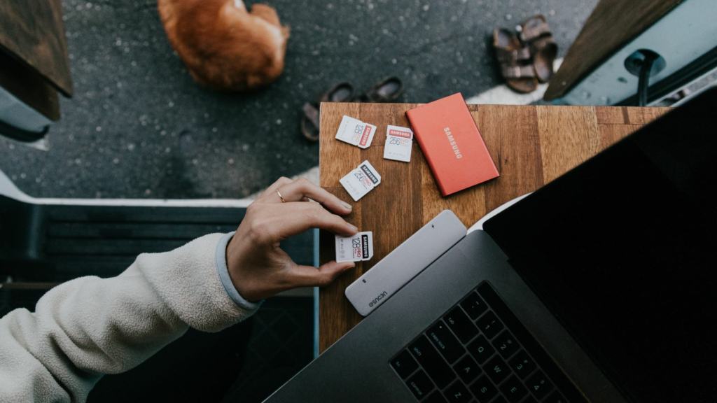 A person inserting an SD card into a Macbook.