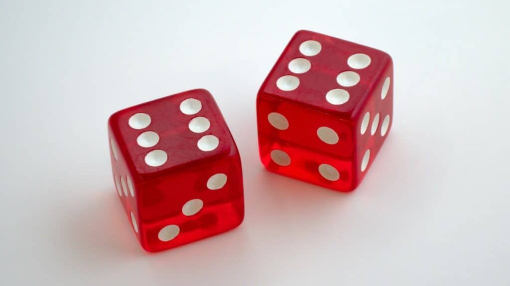 Two dice on a table. Both have the number six on top.